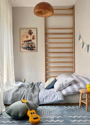 OLYA KIDS Boho Azure speelmat in slaapkamer met kussen en gele ukelele.