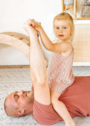 OLYA KIDS Boho Classic schuimpuzzelmat met kind zittend op volwassene in speelkamer.