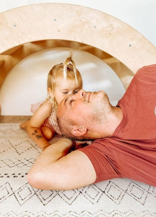 OLYA KIDS Boho Classic schuimpuzzelmat met volwassene en kind onder houten speelboog.