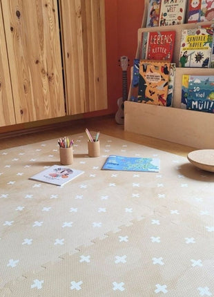 OLYA KIDS Cross Sand speelmat met kleurpotloden en prentenboeken op houten vloer.