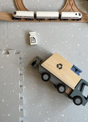 OLYA KIDS Spots Dove speelmat met houten speelgoedtrein en afvalwagen op grijze achtergrond.