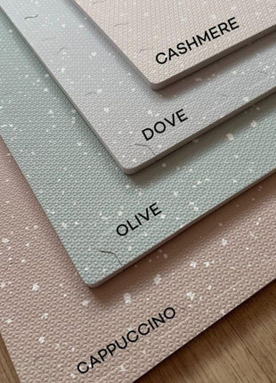Vier OLYA KIDS Stippen speelmatten in de kleuren cappuccino, olive, dove en cashmere op elkaar.