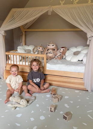 Twee kinderen spelen op de OLYA KIDS Terrazzo Dove speelmat met blokken en knuffel.