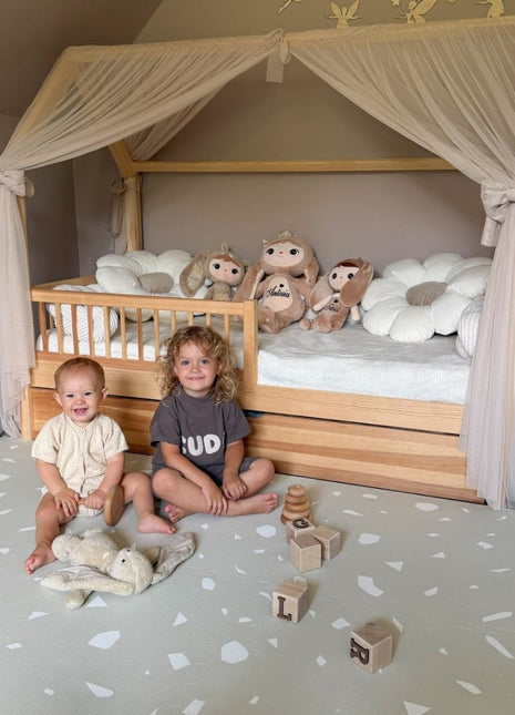 Twee kinderen spelen op de OLYA KIDS Terrazzo Dove speelmat met blokken en knuffel.