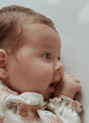 Close-up van babyhoofd en schouder op de OLYA KIDS Terrazzo Lavendel speelmat met terrazzo-patroon.