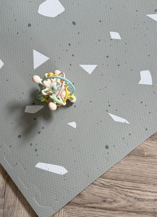 Close-up van OLYA KIDS Terrazzo Sage speelmat met een kleurrijke speelbal.