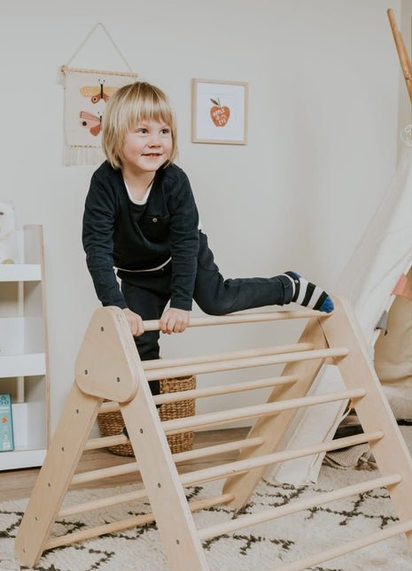Pikler-driehoek - Naturel van leg&go met kind dat over de bovenste spijl klimt.