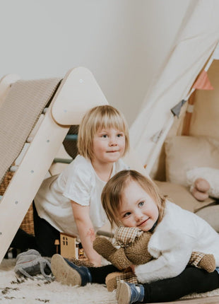 Pikler-driehoek – Pastel van leg&go met twee kinderen die binnenshuis bij de driehoek zitten.