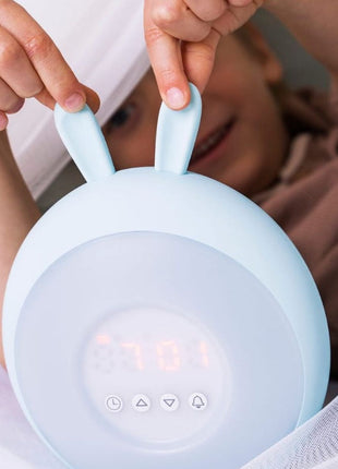 Kind trekt aan de oortjes van Rabbit and Friends Wekkerlamp met Oortjes onder klamboe.