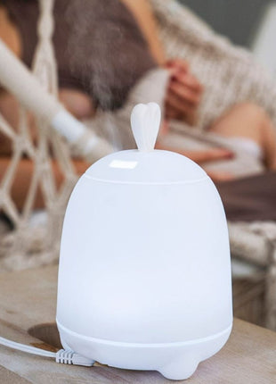 Rabbit & Friends Diffuser Lamp met konijnenoren en zichtbare nevel op tafel.