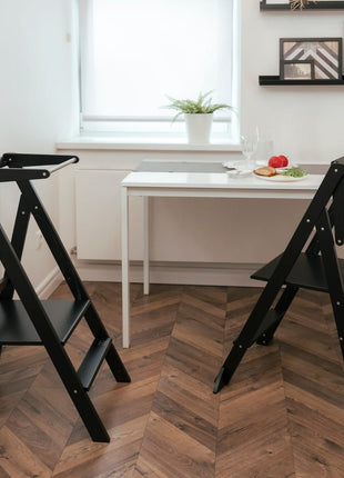 Twee STEP'n'FOLD opvouwbare keukentorens zwart geplaatst bij een eettafel