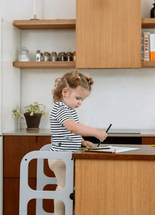 Peuter tekent aan het keukeneiland in de STEP'n'SIT® 2-in-1 keukentoren grijs