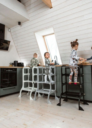 Vier kinderen gebruiken verschillende STEP'n'SIT® 2-in-1 keukentorens aan het keukenblad