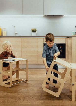 Kind klapt de STEP'n'SIT® 2-in-1 keukentoren naturel om van torenstand naar tafelstan
