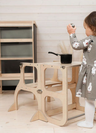 Kind speelt met pan op de STEP'n'SIT® 2-in-1 keukentoren naturel met steunpoten in tafelstand