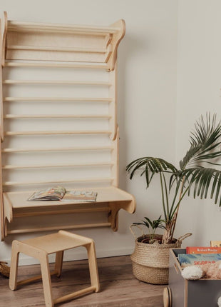 Zweedse klimwand met gemonteerde tafel en losse houten stoel in speelkamer