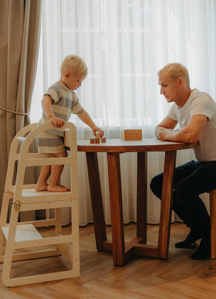Kind staat op witte Leg&Go transformeerbare keukentoren 2-in-1 aan tafel samen met vader.