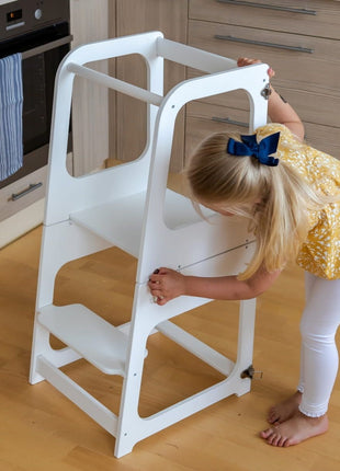 Kind vergrendelt witte Transformeerbare Keukentoren in keukenruimte.