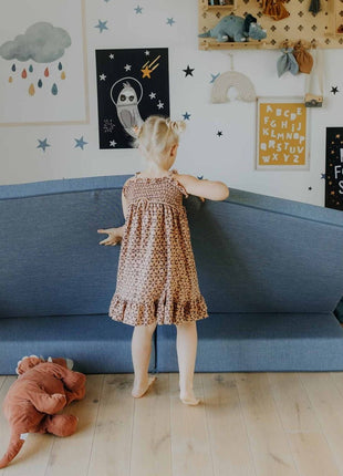 Meisje opent onderdeel van de turquoise Monboxy Montessori speelbank – toont toegankelijkheid en flexibiliteit voor jonge kinderen.