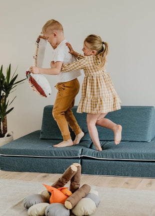 Kinderen spelen op de turquoise Monboxy Montessori speelbank in een ingerichte kinderkamer – geschikt voor rollenspel en motorische ontwikkeling