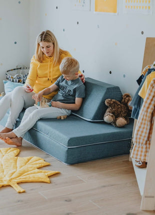 Moeder en kind spelen samen op de turquoise Monboxy Montessori speelbank – versterkt ouder-kind interactie in een kindvriendelijke setting.
