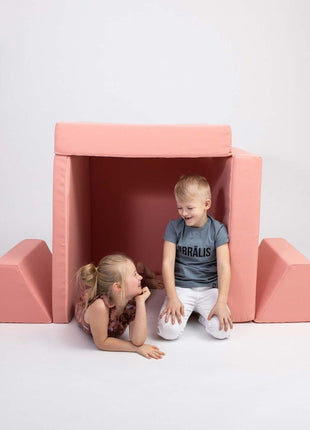 Twee kinderen spelen in een speelhutconstructie van de Monboxy Montessori speelbank – tentvorm voor fantasierijk spel.