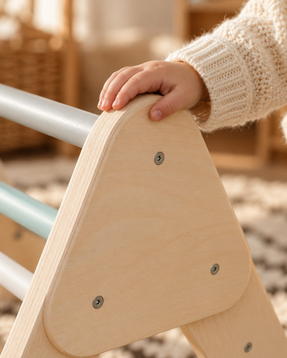 Een kinderhand op de afgeronde rand van berkenhout.